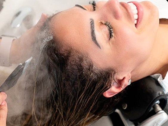 Cliente recebendo terapia capilar no lavatório
